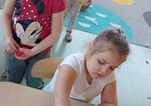 Dzieci wyklejania bibułą flagę Polski.